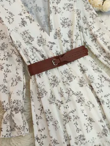 Close-up of the vintage bohemian floral print fabric and brown leather waist belt.