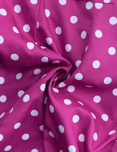 Macro view of high-quality magenta fabric with classic white polka dot pattern and soft drape