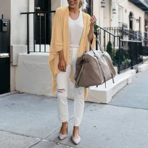 Stylish loose mustard yellow knit cardigan with irregular hem in urban street style