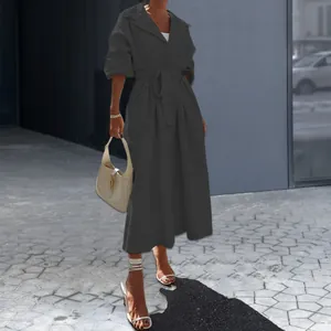 Elegante donkergrijze midi-trenchcoatjurk met lange mouwen en een stijlvol ceintuurontwerp.
