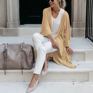 Stylish women's mid-length loose knit cardigan with irregular hem in lifestyle setting