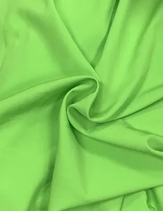 Detailed macro view of vibrant lime green fabric texture for elegant summer banquet dress