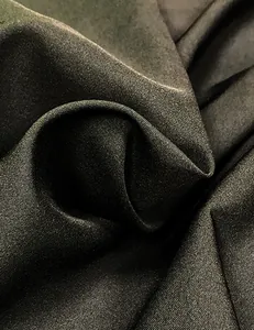 Close-up of black evening dress fabric showing detailed twill texture and soft sheen.