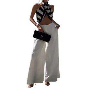 Elegant white high-waisted wide-leg trousers paired with a chic vacation style halter top