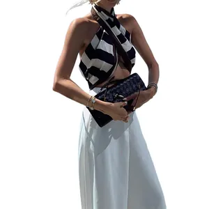 Chic style with white wide-leg trousers and a striped halter top for a vacation look