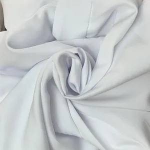 Close-up detail showing the soft texture and weave of white solid color fabric for pants.