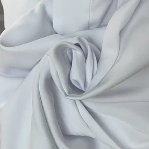 Close-up view of high-quality white fabric texture for elegant wide-leg trousers