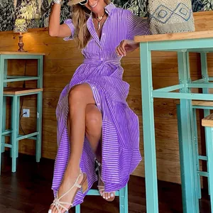 Lifestyle view of a woman wearing a purple striped short-sleeve maxi shirt dress
