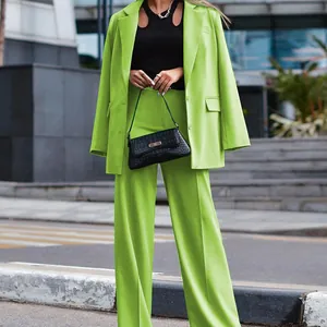 Detail of lime green two-piece suit set in a modern urban street setting.