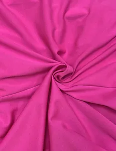 Macro view of vibrant hot pink dress fabric showing smooth texture and soft elegant drape