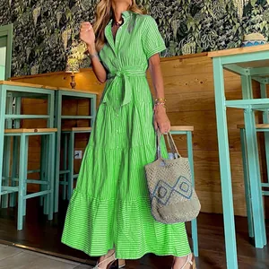 Detailed view of a green striped short sleeve tiered maxi dress in a cafe setting