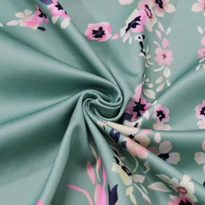 Close-up detail of green bohemian floral print fabric texture for women's dress