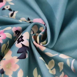 Macro detail of teal floral print fabric featuring soft texture and vibrant pink blossoms