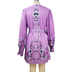 Back view of bohemian floral print mini dress in purple with long sleeves and belt.