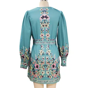 Back view detail of a teal bohemian mini dress with vibrant floral prints and long sleeves
