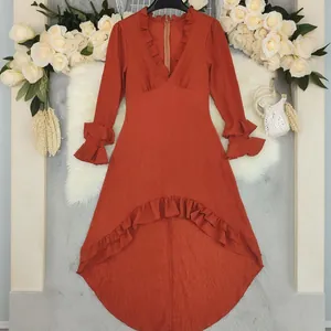 Elegante terracotta jurk met V-hals, ruches en een asymmetrische hoog-laag zoomlijn.