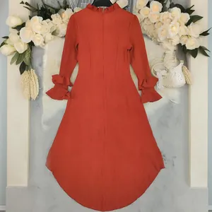 Elegante terracotta maxi-jurk met lange mouwen, ruches aan de manchetten en een hoge-lage zoom
