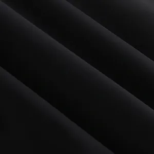Κοντινό πλάνο υφάσματος μαύρης καπαρντίνας με λεία υφή και μαλακές πτυχές