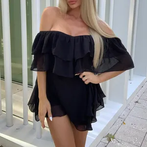 Primo piano del mini abito nero con spalle scoperte e balze in chiffon.