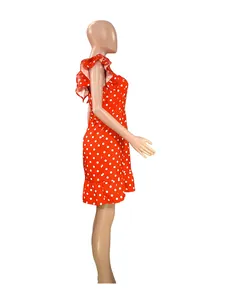 Side view of a vibrant red polka dot mini dress with ruffle fly sleeves on a mannequin