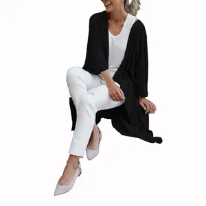 Detailed shot of women's loose fit long black knit cardigan featuring an irregular hem