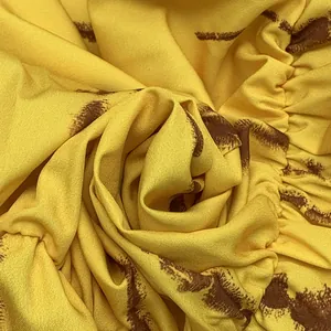 Primo piano del tessuto giallo con stampa bohémien marrone per un abito da donna