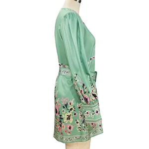 Detailed side view of green Bohemian floral mini dress with elegant long cuffed sleeves