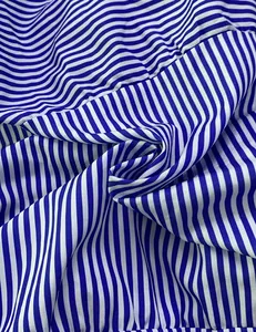 Close-up detail showing the texture of blue and white striped fabric for fashion dresses.