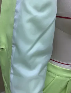 Close-up detail of the smooth lime green lining and fabric texture of the women's blazer