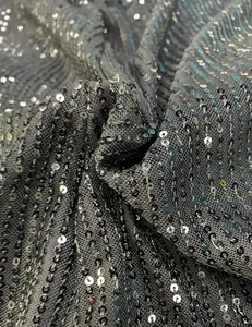 Close-up macro view of high-density sequin fabric on a dark mesh base for evening dresses