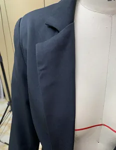 Detailed close-up of a black casual blazer lapel showing fine fabric texture on a mannequin.