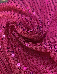 Macro close-up detail of shiny pink sequin fabric with mesh backing for evening dresses
