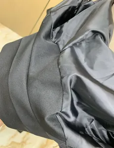 Close-up of the smooth black lining and textured fabric of a women's casual blazer