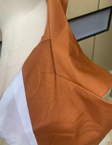 Close-up detail of burnt orange long sleeve casual blazer fabric and shoulder seam