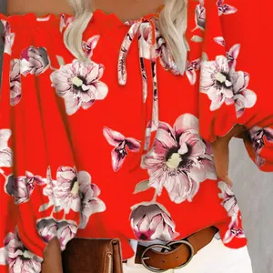 Close-up of a red floral off-shoulder top with long sleeves and elegant tie detail