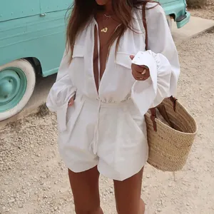 Macro detail view of a white loose cotton linen romper featuring long sleeves and pockets