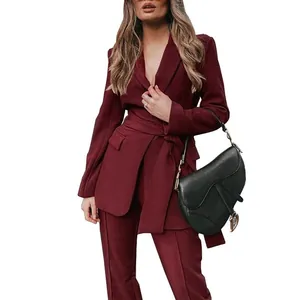 Detail van een chique bordeauxrode blazer met riem en bijpassende broek.