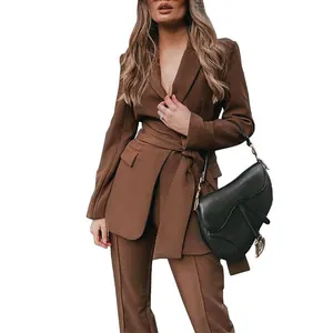 Detailweergave van bruin tweedelig pak met blazer met ceintuur en bijpassende pantalon