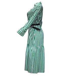 Side view of a green and white striped long sleeve maxi dress with a black belt