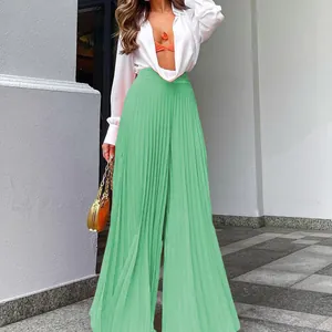 Modische mintgrüne Plissee-Hose mit weitem Bein für Damen in eleganter Außenaufnahme