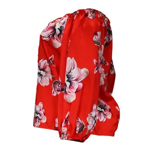 Detailed side view of off-shoulder red blouse featuring large pink floral print patterns