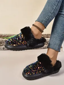 Primer plano de pantuflas de lentejuelas para mujer con piel sintética negra y suela gruesa
