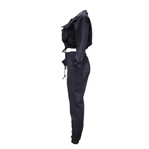 Profile view of black two-piece women's tracksuit set with cropped jacket and jogger pants