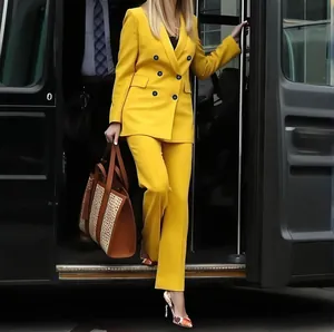 Detail view of a vibrant yellow women's double-breasted suit with straight trousers.