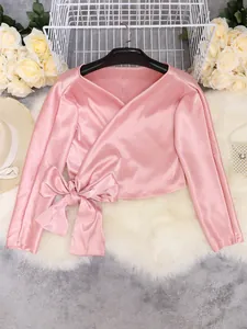 Elegant pink satin V-neck wrap top featuring a large decorative bow tie at the waist