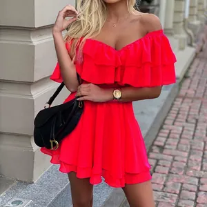 Primo piano di un mini abito sexy in chiffon rosa fluo con spalle scoperte e balze a balze.