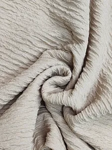 Dettaglio ravvicinato dell'elegante trama del tessuto plissettato beige da donna