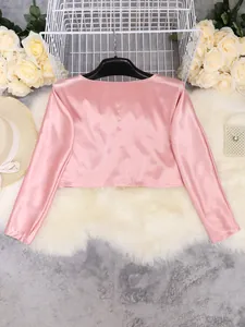 Back view of pink satin long sleeve crop top showing smooth glossy fabric texture