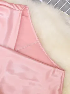 Detail of smooth pink satin fabric and neat stitching on a women's elegant top