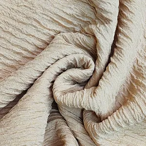 Detailed macro shot of beige textured crinkle fabric for chic women's casual lounge suit.